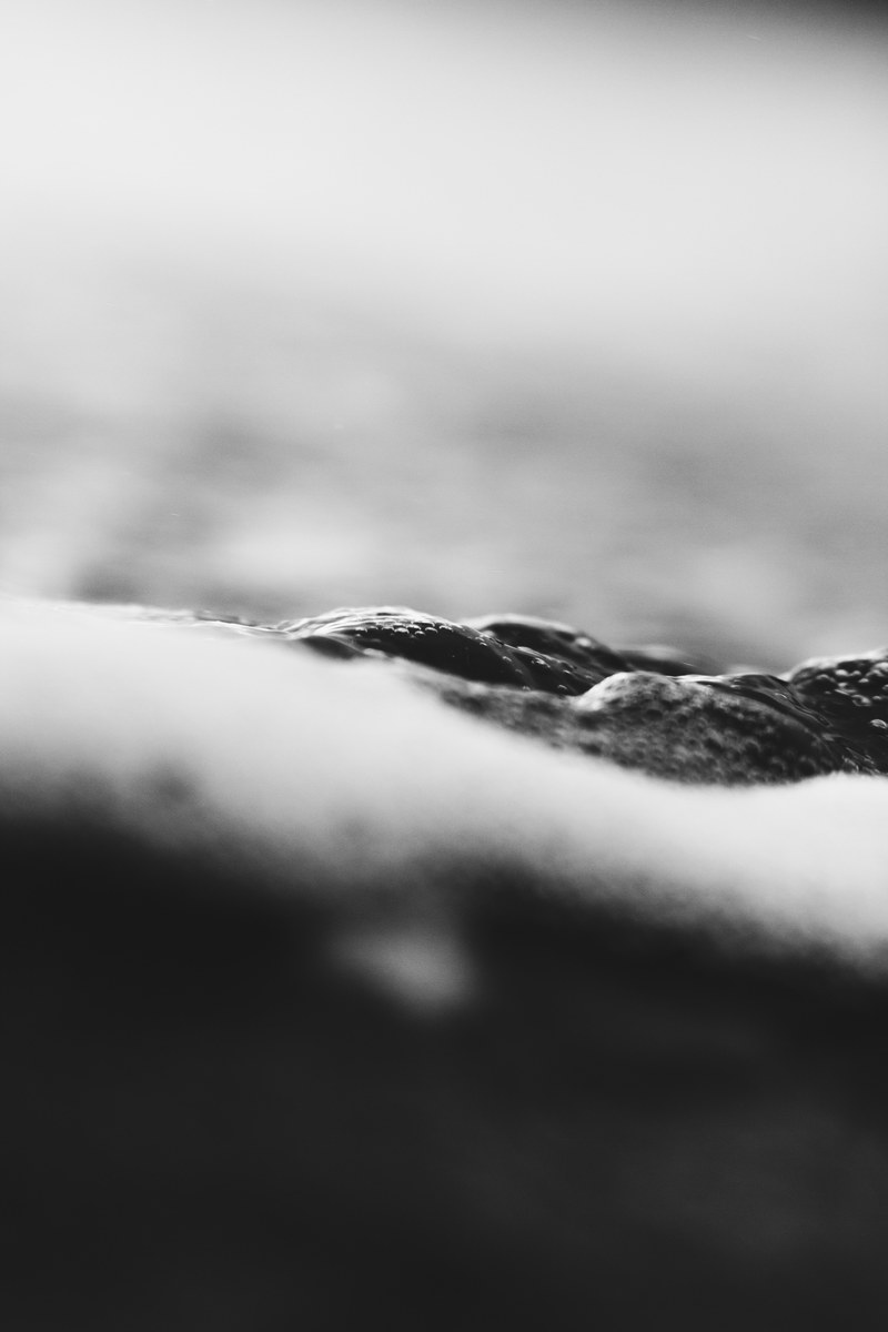 black and white macro of water and bubbles with blurred background, black waters of piha 2 4k