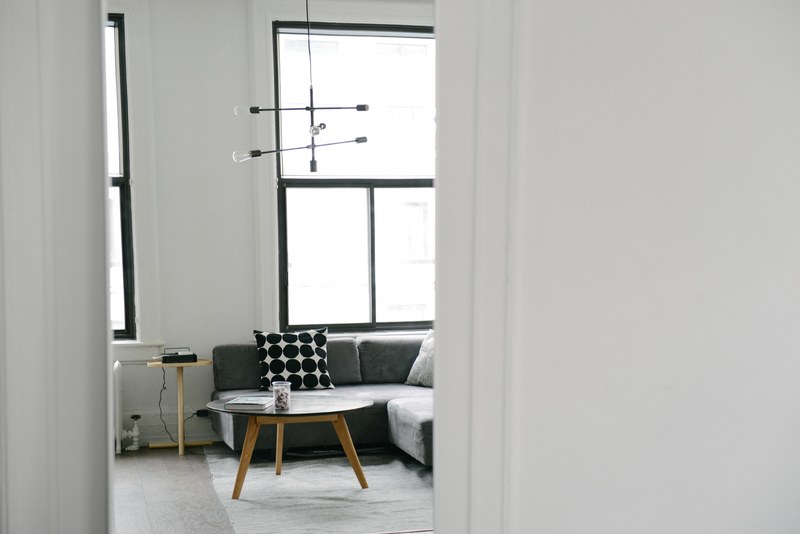 a cozy interior with large windows and a coffee table next to a sofa, cozy interior with a sofa 4k