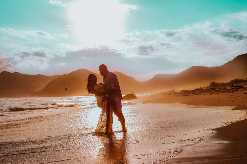 happy romantic couple holding each other on a sand beach during sunset in praia de grumari, romantic couple on a beach 4k