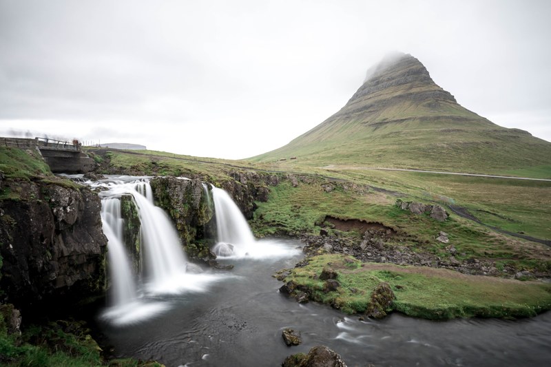 waterfalls cascade into calm waters near a mountain in grundarfjrur, cascading waters 4k