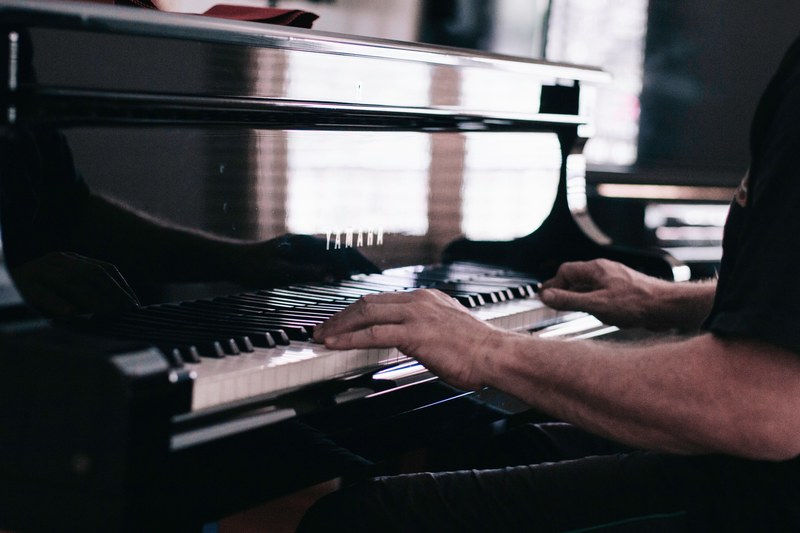 a fuzzy shot of a mans hands on the keyboard of a piano, piano reflection 4k