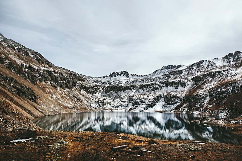 the round blue lake surrounded by snow capped mountain ridges, ridges around blue lake 4k