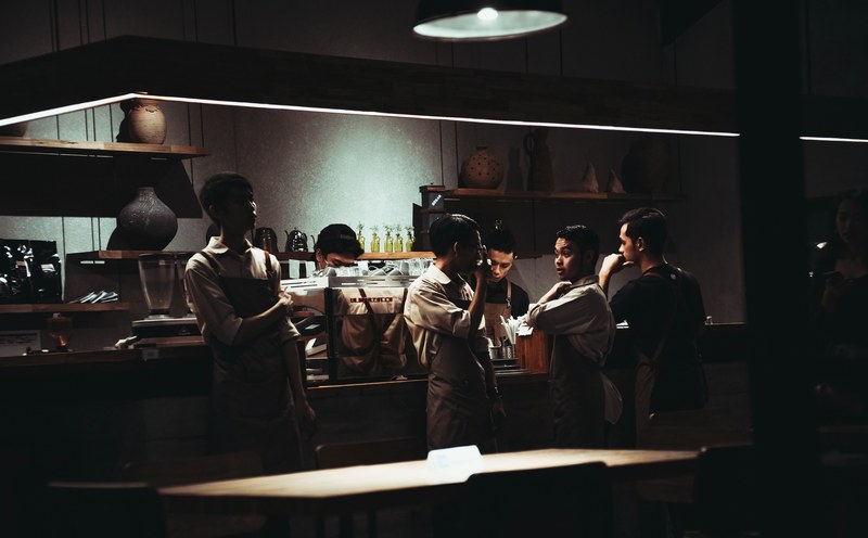 staff socialize around the bar at a dimly lit restaurant, restaurant crew socializing 4k
