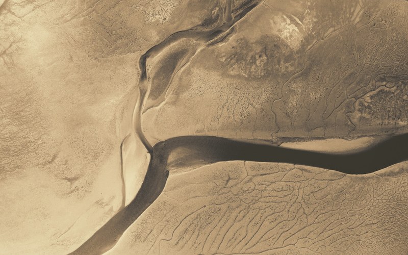 a drone shot of a river flowing through an arid plain, river in an arid plain 4k