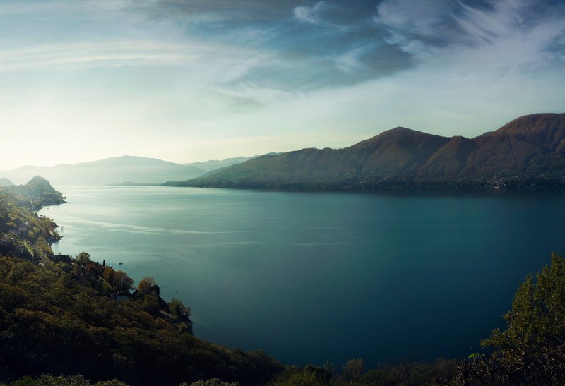 a high shot of a vast lake surrounded by mountains, mountains on the opposite shore 4k