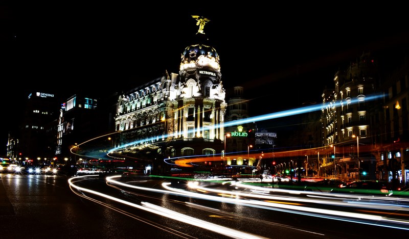 a dark shot of urban buildings lit up at night in madrid, metropolis at night 4k
