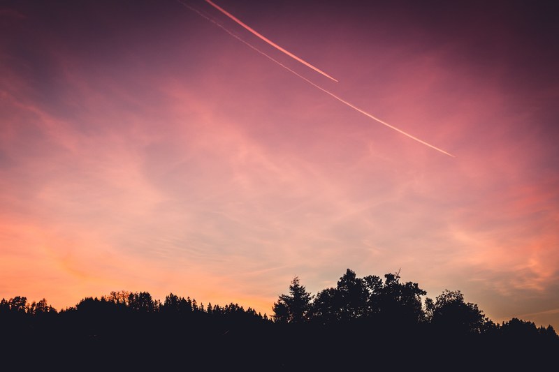 red and orange sunset against a forest silhouette in austria, austrian forest sunset_ 4k