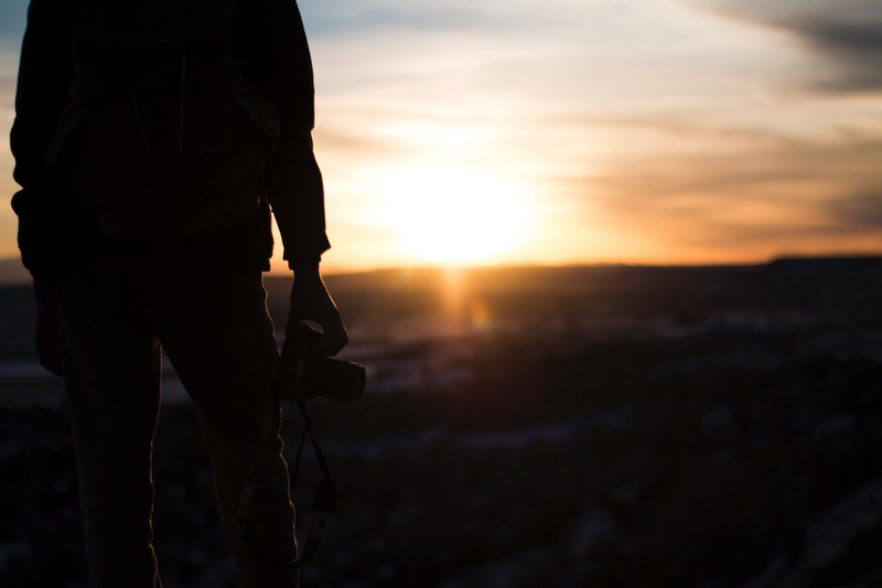the silhouette of a photographer holding a camera during sunset or sunrise in billings, billings photographer sunset 4k