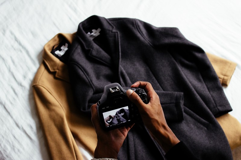 a person taking a photo of two coats with a camera, photographing coats 4k