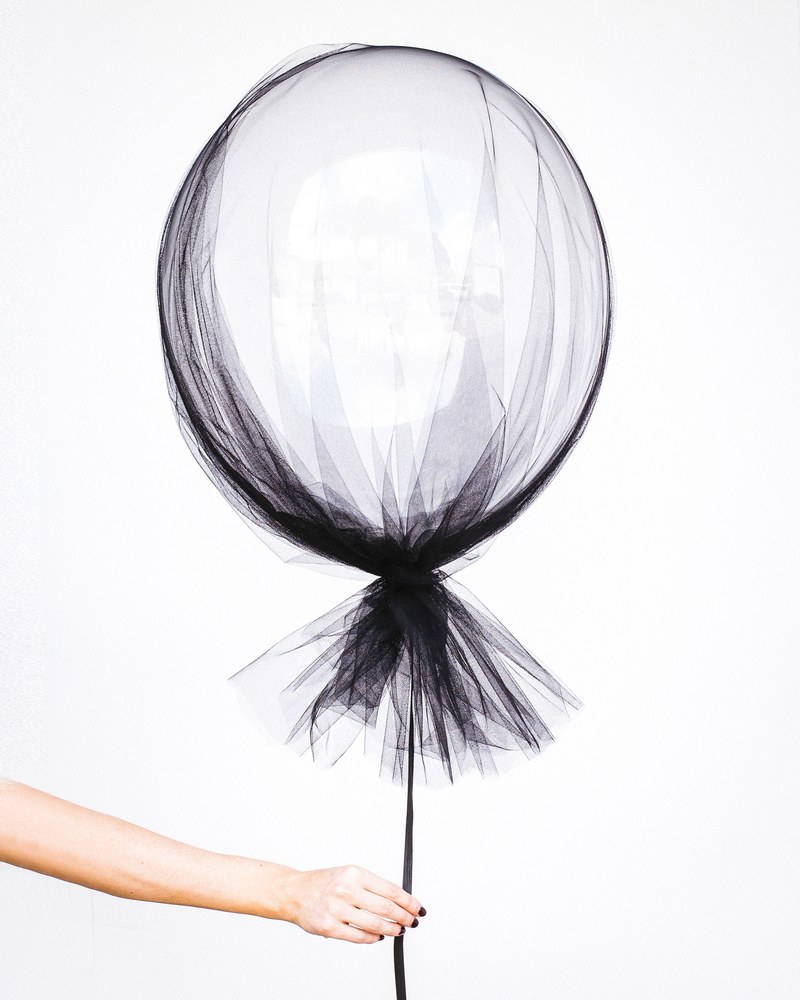 a woman holding a white balloon on her hand with a black string in sydney, a womans white balloon 4k