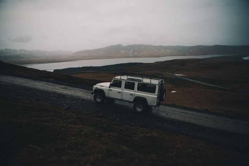 a white suv driving up a dirt road in the mountains, the climb to dyrhlaey 4k