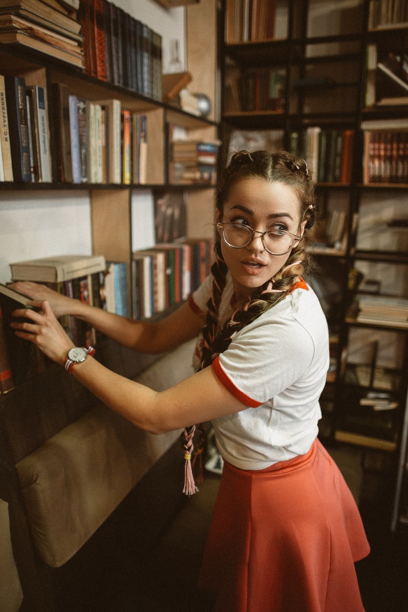 woman in a vintage outfit putting away a book in a store, putting away books 4k