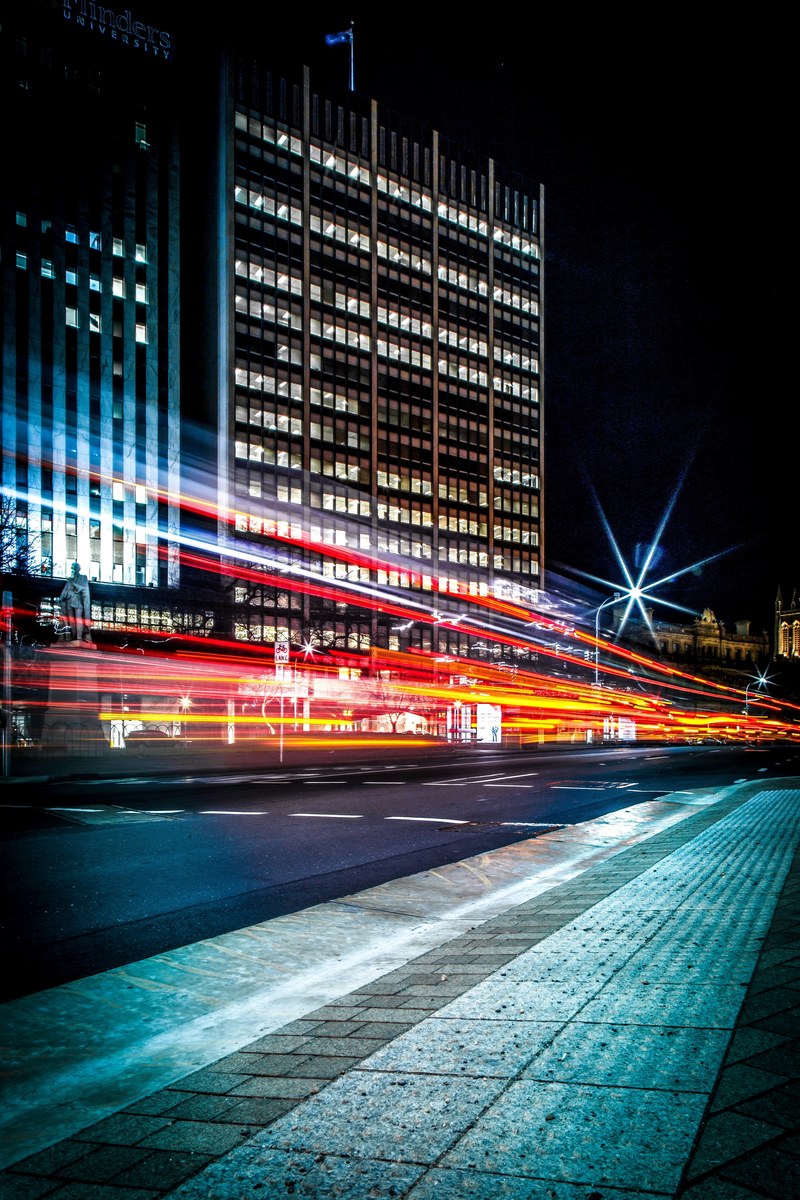 red light trails over a road in a city, light trails over urban road 4k