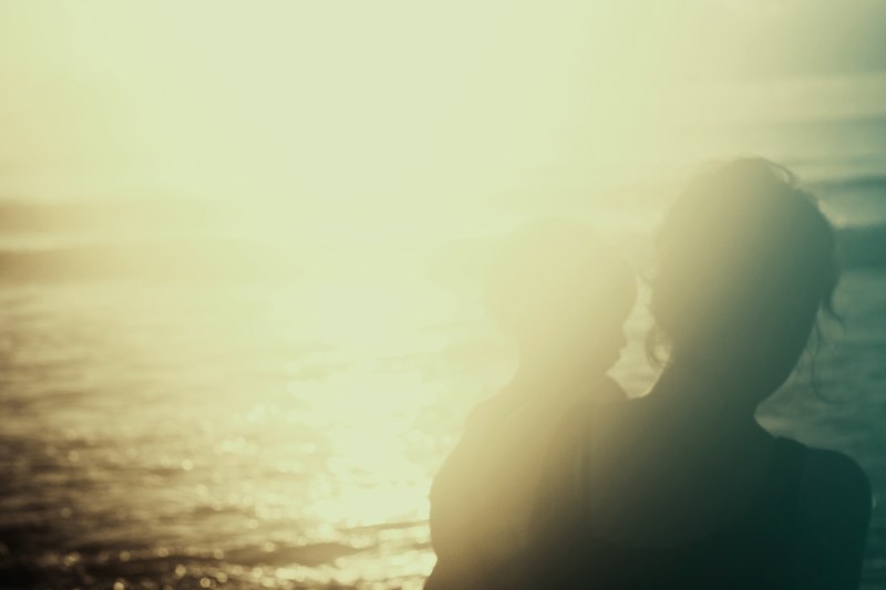 woman holding a child in an overexposed photograph by the ocean at cocoa beach, photo of woman holding child 4k