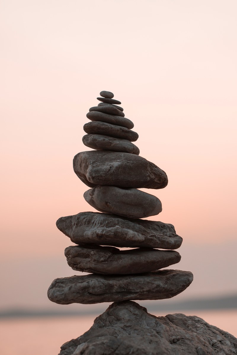 a stack of rocks against a pink sky, balance 4k