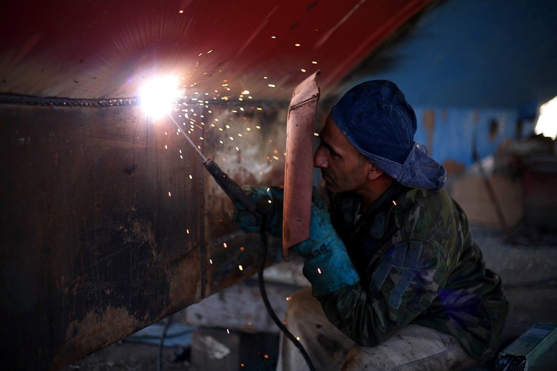 a man welding a steel sheet in a workshop, welder in a workshop 4k
