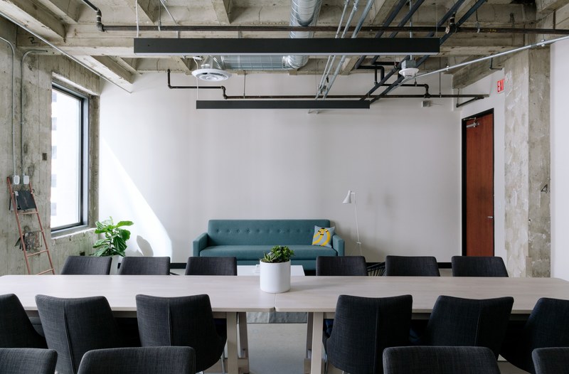 a meeting space in an office with two long tables and a sofa, 601 w 5th street los angeles california 4k