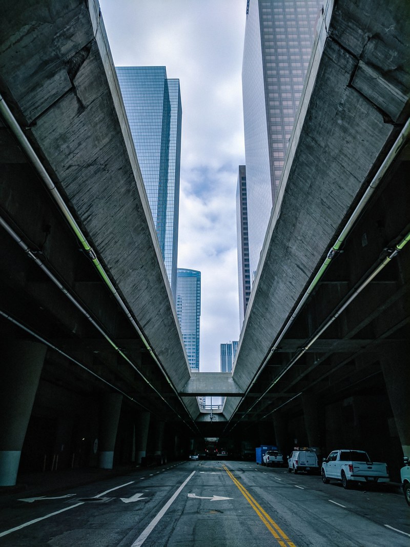 an urban city street with a long building facade shadowing above in los angeles, los angeles underground 4k