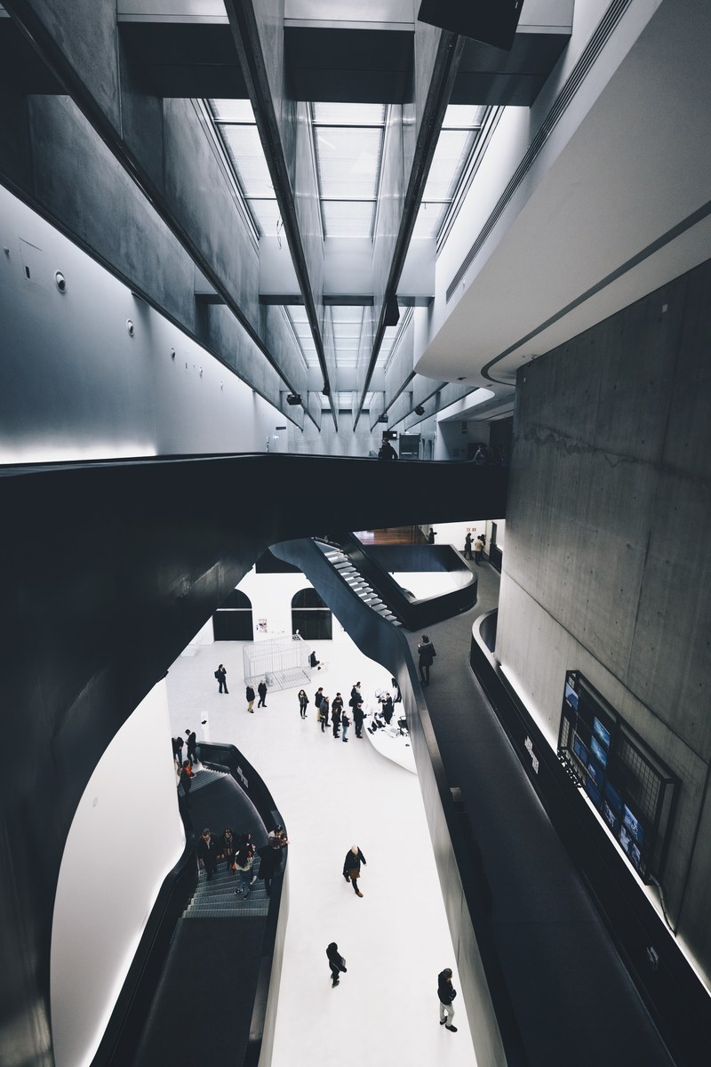 a high view of visitors on the white floor of a modern museum, modern museum visitors 4k