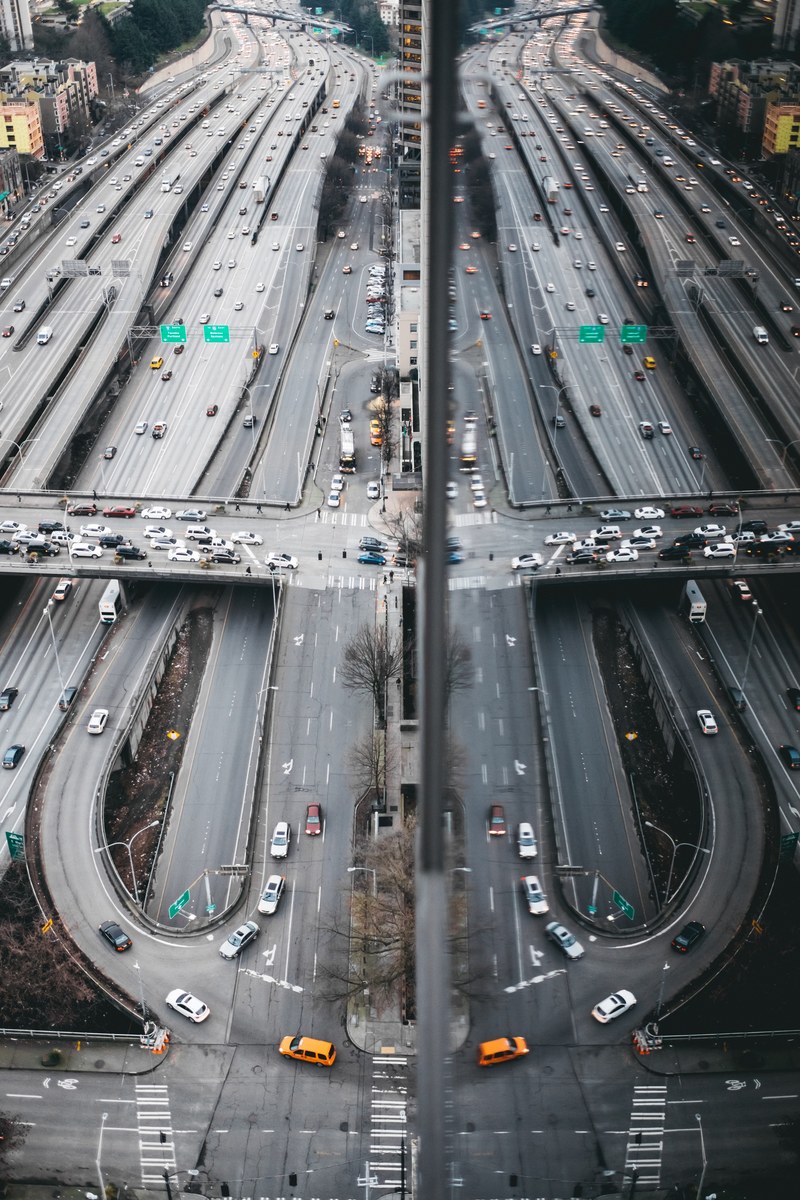 highway roads reflect in buildings to form loops and lines, karma 4k