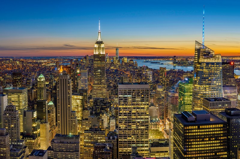new york city skyline with skyscrapers lit up while sun sets, new york lights 4k