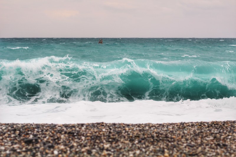 wave crashing with foam on the pebble beach, 4k
