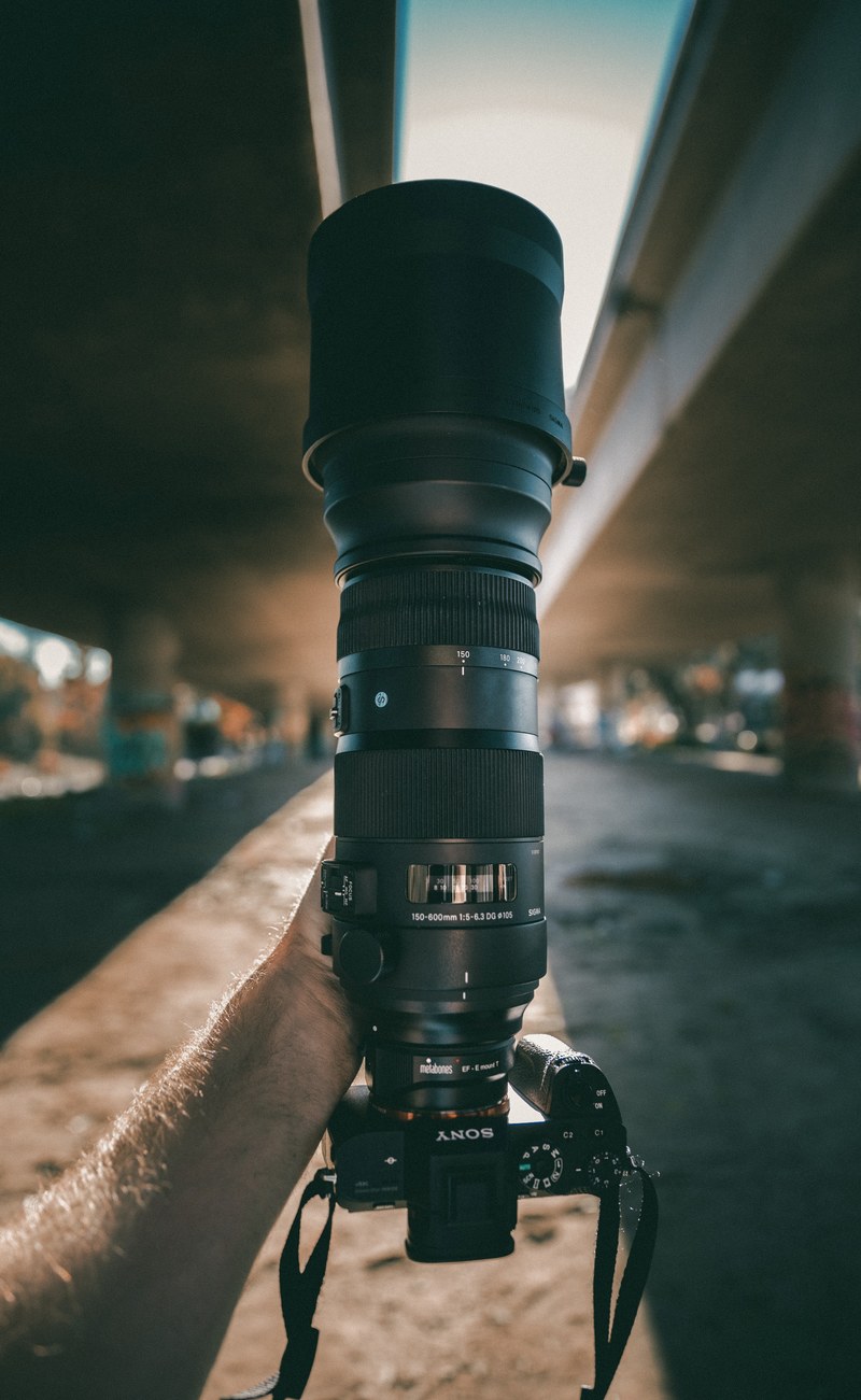 photographers sony camera on a ledge outside, sigma canon lens 4k