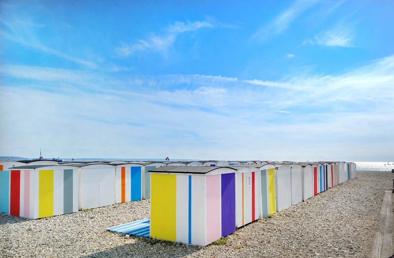 colorful beach changing rooms at the pebble beach in le havre, summer wooden houses by the sea 4k