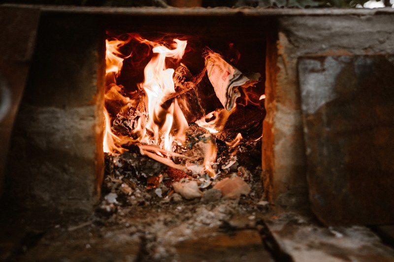 fire consuming scraps of newspaper and woodfire in a stone floor fireplace, fireplace with newspaper and logs 4k