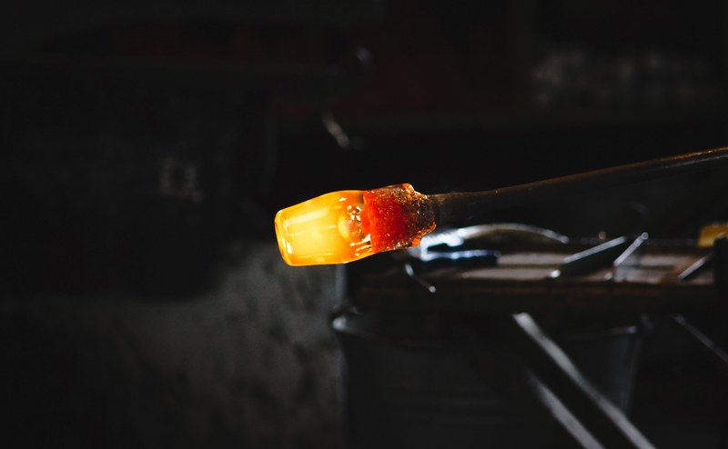 glass blowing rod with molten red hot glass on the end in a glass blowing workshop, glass in the making 4k