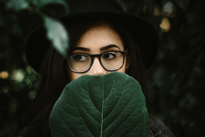 woman with bold eyebrows and thick rimmed glasses behind a leaf, so take a deep breath and let it go 4k