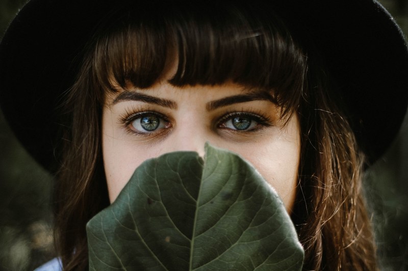 woman hiding behind a leaf and peeking over the top, can you read my mind 4k