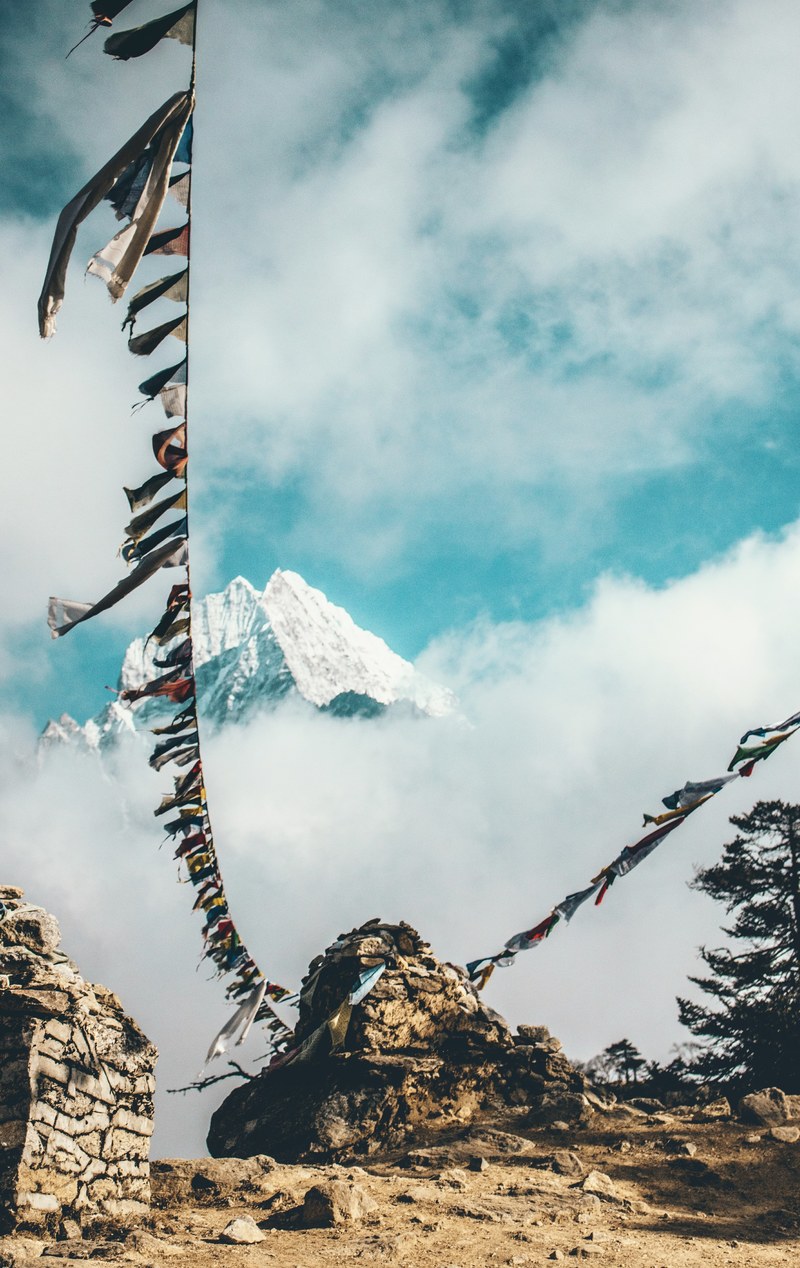 a long line with colorful flags in tall mountains in nepal, fluttering dreams 4k