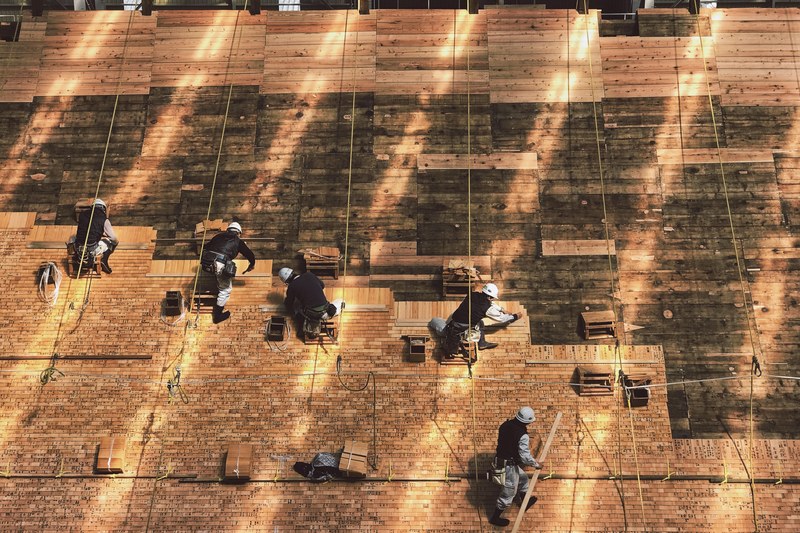 construction workers laying out tiles on a roof, 4k