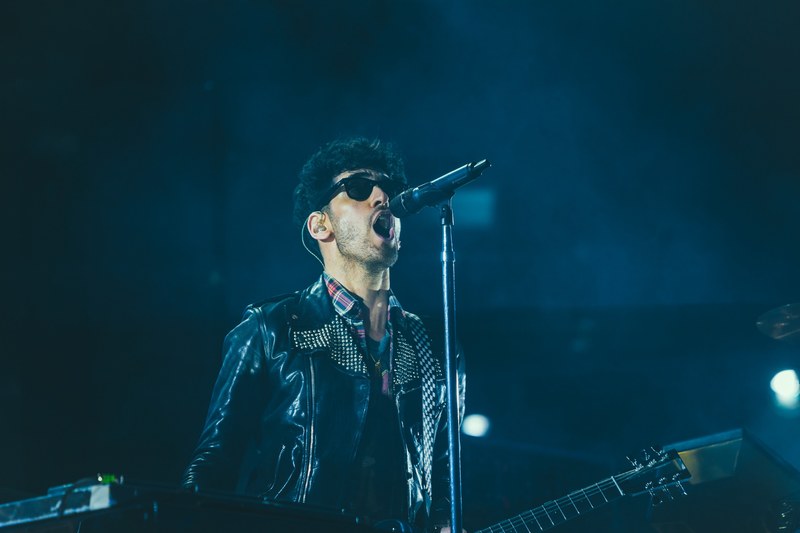 musician in a rock band sings into a microphone on stage, singer in concert 4k
