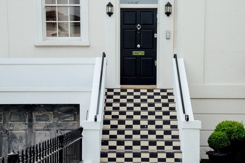 checkered black and white residential outdoor stairway and black door in london, black and white house stairs 4k