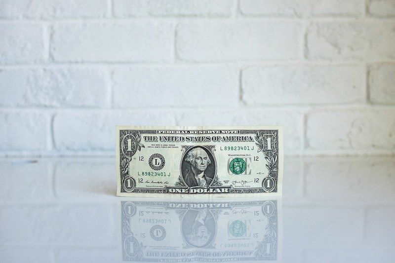 a one dollar bill leaning against the wall on a glossy surface, one dollar bill by the wall 4k