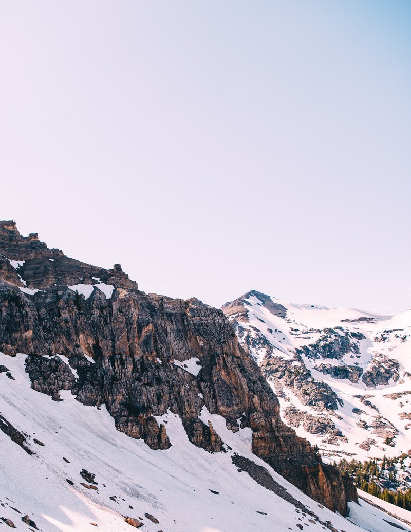 craggy rock towers jutting out from a snowy mountain slope, craggy mountainside 4k
