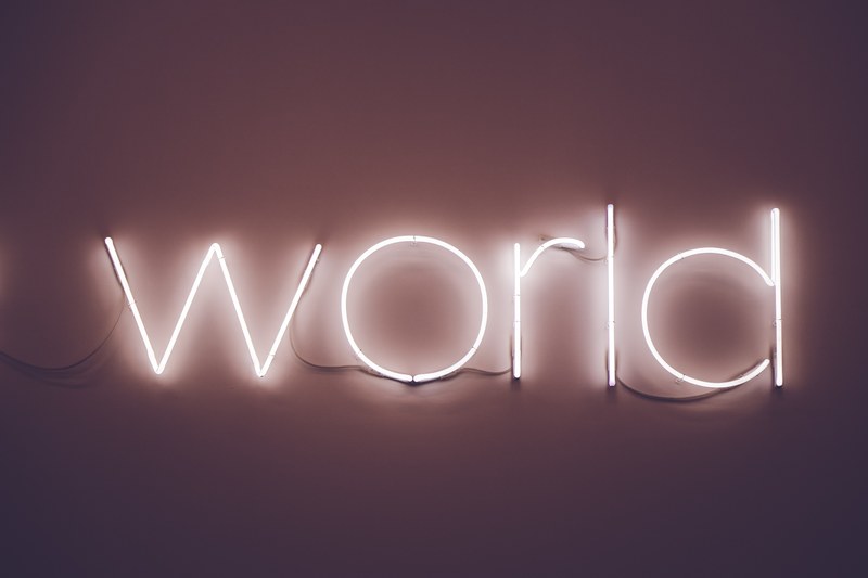 a white neon on a wall reads world, world 4k