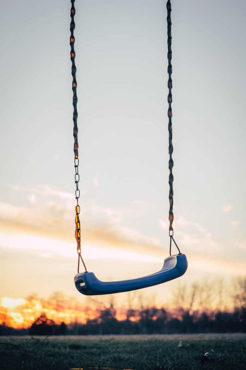 the macro view of a swing on grass at sunset, swing from my childhood 4k