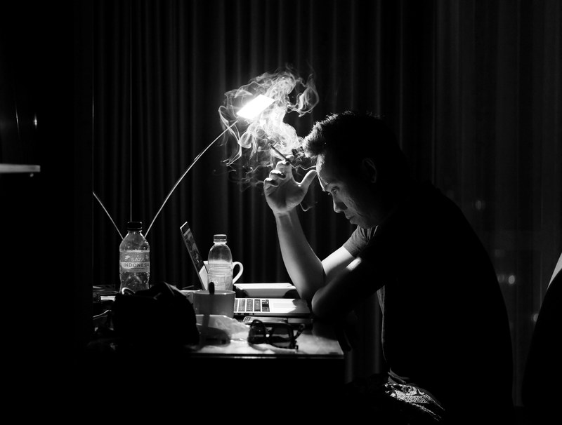 a man sitting at his desk staring at his computer smoking a cigarette, let the heavy thoughts go in smokes 4k