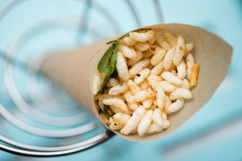 a puffed rice snack in a brown paper wrap, jhalmuri in a paper cone 4k