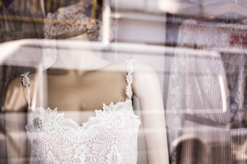a lacy wedding dress on a mannequin in a shop window display, wedding dress on mannequin 4k