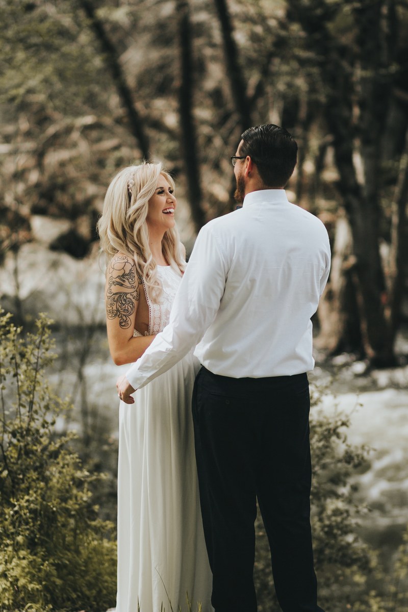 a bride in a white dress smiling brightly to her future husband in a white shirt, bride groom at river 4k