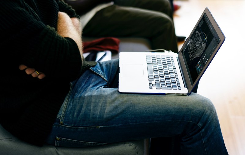 a man sitting with his arms crossed looking at his laptop, man sitting with laptop 4k