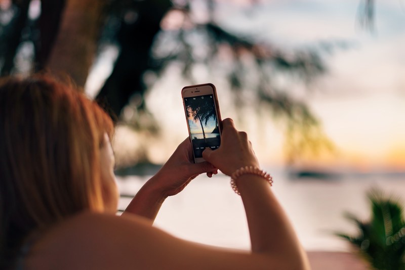 woman taking a photo of the palm tree with an iphone at koh chang, koh chang sunset 4k