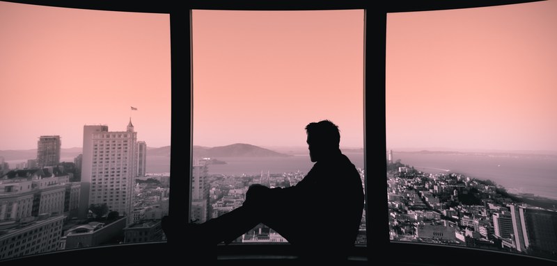 a silhouette of a man sitting on a windowsill and looking out the window, went up the wrong elevator 4k