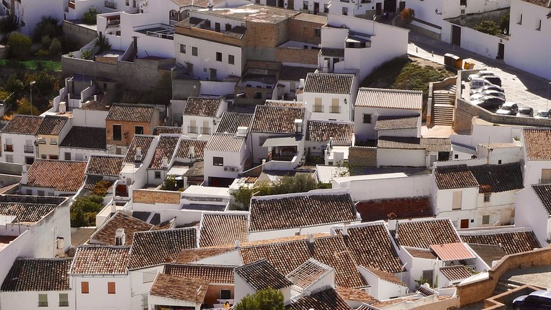 drone view of white houses with brown roofs, urban rooftops 4k