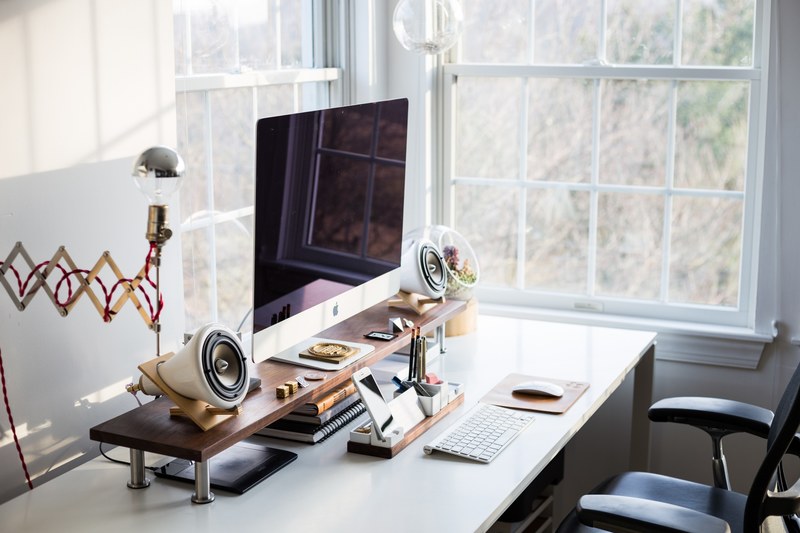an orderly desk with an imac and an iphone in a bright room corner with two windows, workspace organization 4k