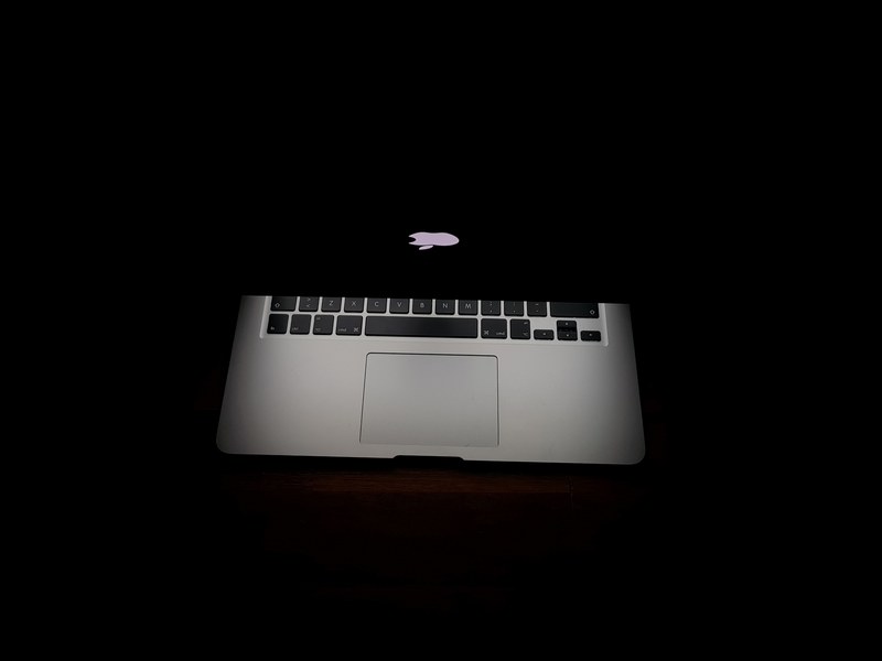 half closed macbook laptop illuminates dark background, macbook darklight 4k